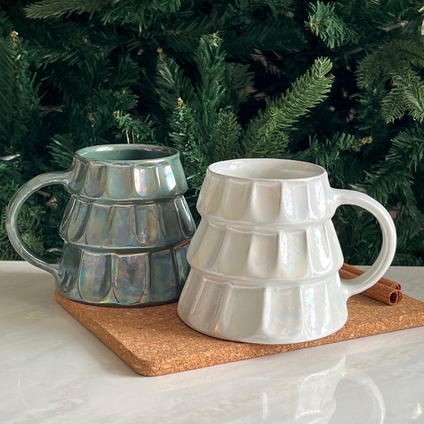 Festive handmade mugs in green and white, designed as Christmas trees with an elegant finish.