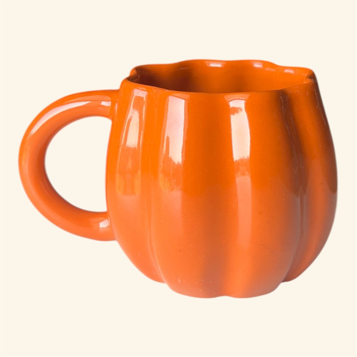Orange pumpkin-shaped mug on a white background